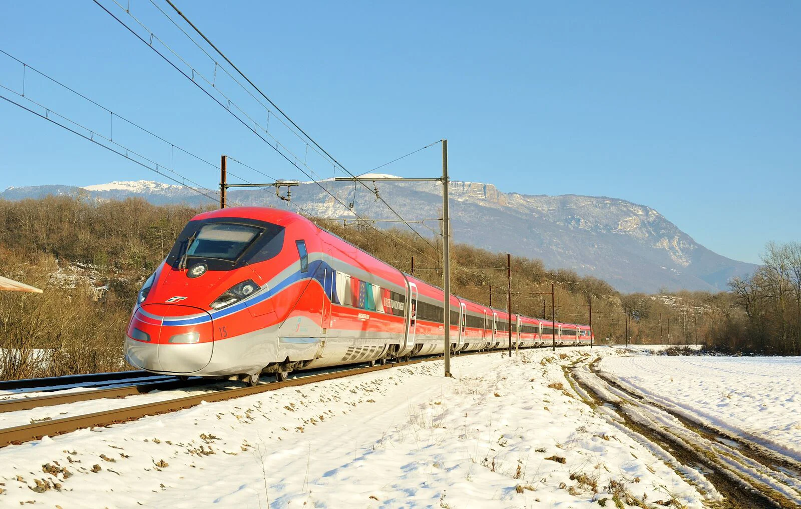 Train Frecciarossa roulant dans un paysage enneigé.