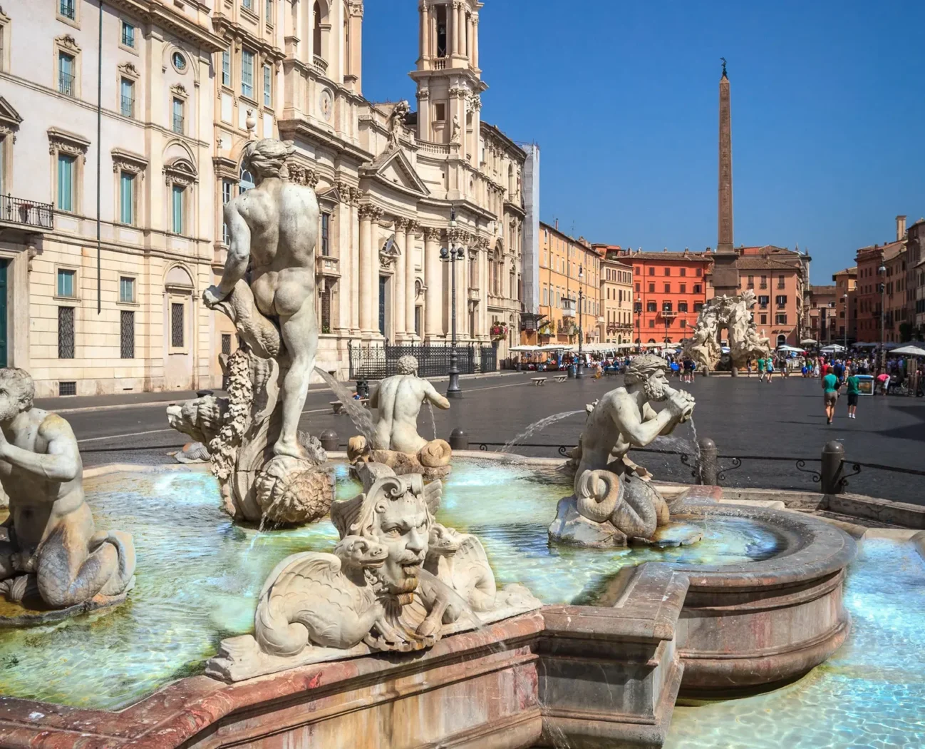 Fontaine du Neptune sur la Piazza Navona à Rome, avec sculptures baroques, façades colorées et obélisque au fond.