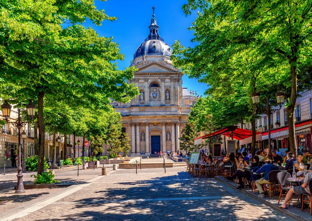 Place de la Sorbonne à Paris avec ses terrasses de café et la chapelle universitaire en arrière-plan.