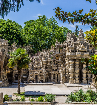 Palais idéal du Facteur Cheval entouré de verdure.