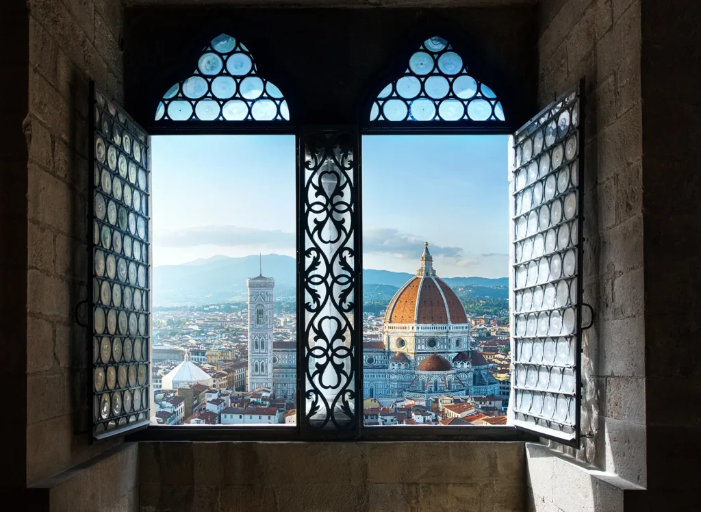 Vue sur la cathédrale Santa Maria del Fiore de Florence à travers une fenêtre gothique.