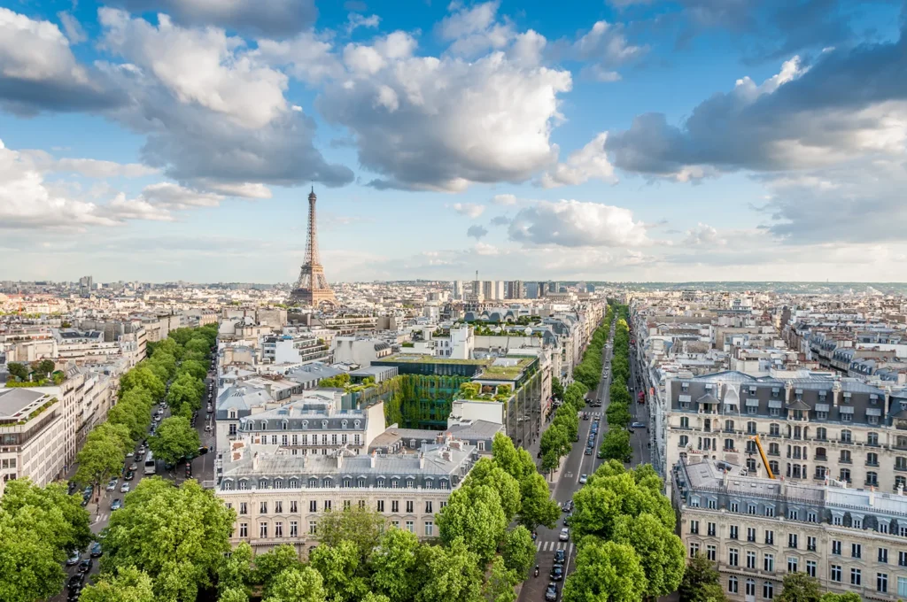 Vue aérienne de Paris avec la tour Eiffel et les avenues verdoyantes.