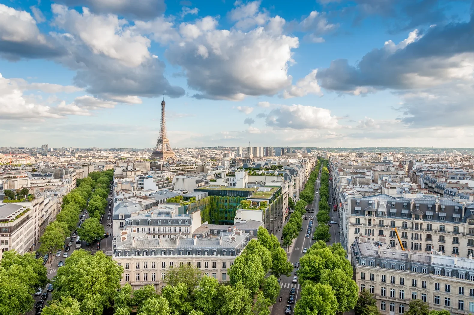 Vue aérienne de Paris avec la tour Eiffel et les avenues verdoyantes.