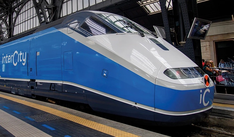 Train à grande vitesse bleu et argent stationné en gare sous une verrière moderne