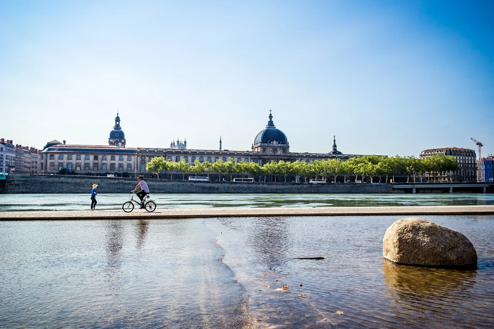 Balade à vélo sur les berges du Rhône à Lyon, face à l’Hôtel-Dieu.