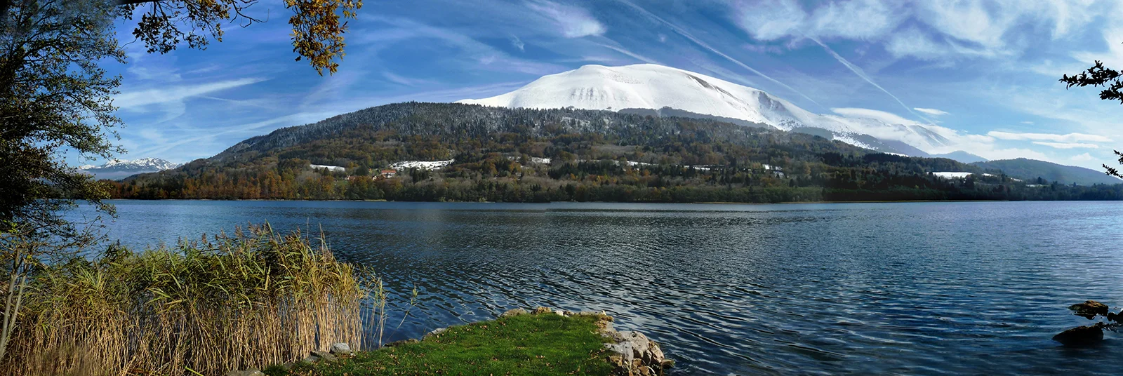 Lac du Bourget avec vue sur la montagne enneigée en Savoie, sous un ciel bleu.