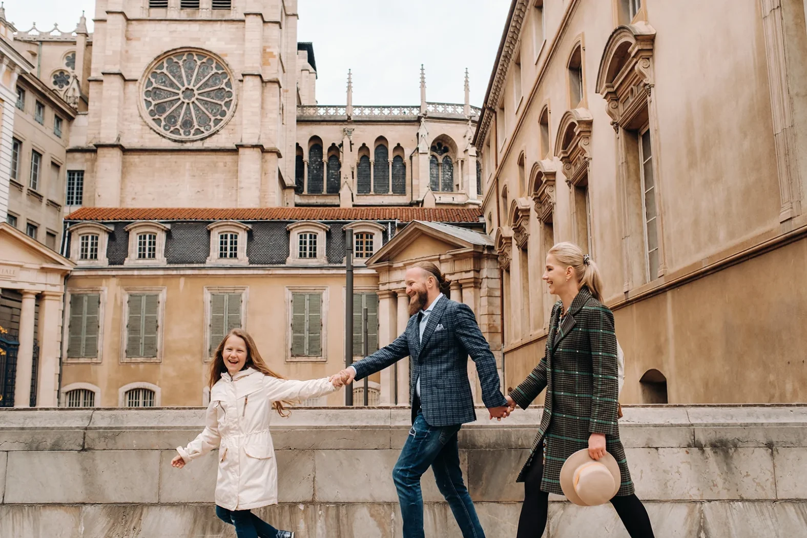 Famille se promenant dans le Vieux Lyon devant la cathédrale Saint-Jean.