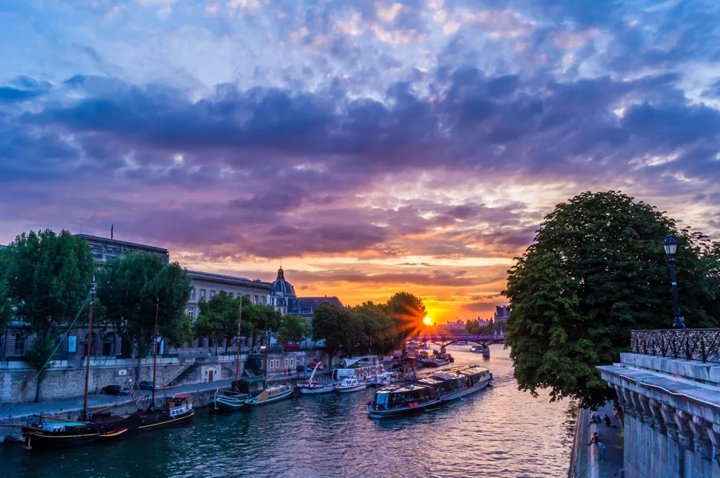Coucher de soleil sur la Seine avec les péniches et les quais de Paris.