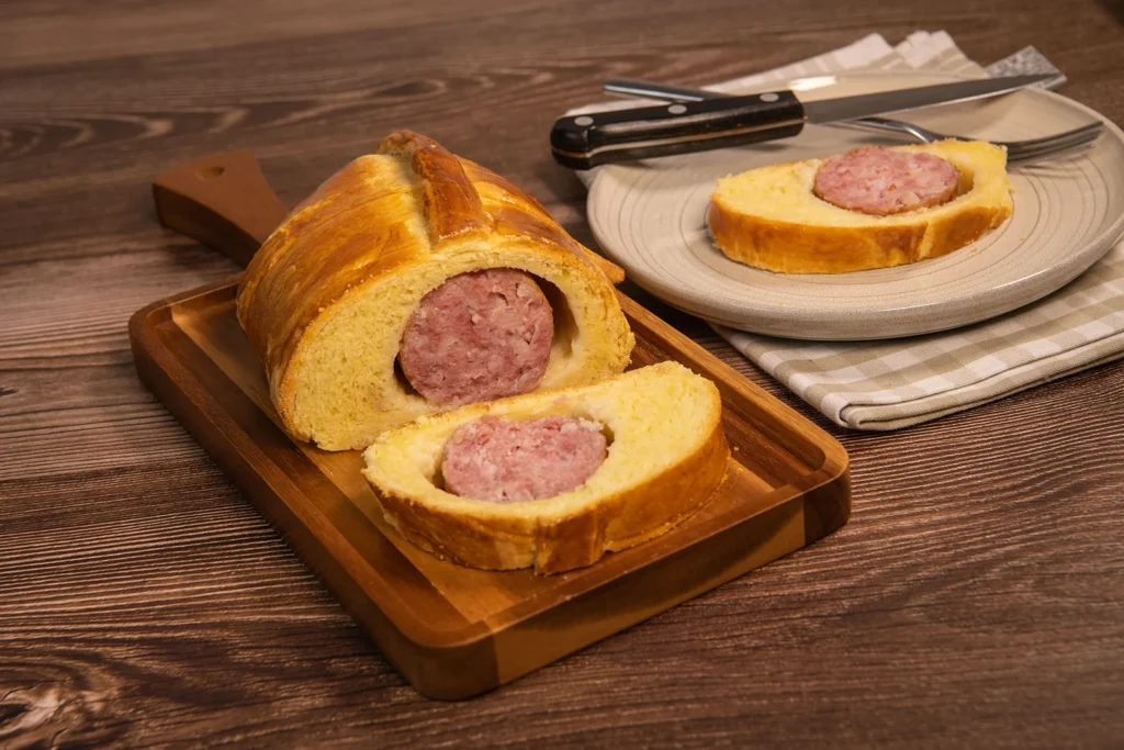 Saucisson brioché, spécialité lyonnaise, coupé en tranches sur planche en bois.