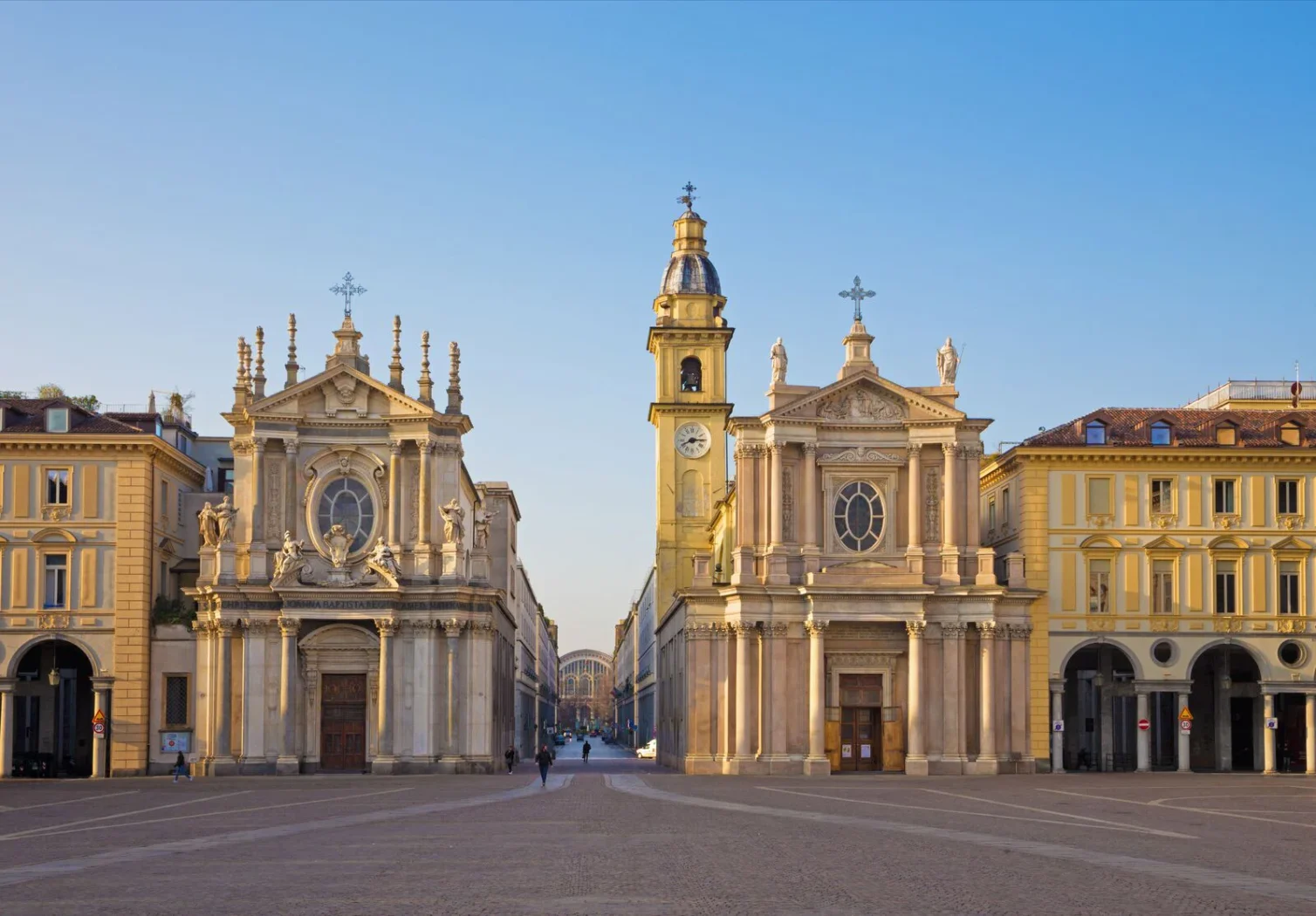 Vue sur la Piazza San Carlo à Turin avec les églises jumelles Santa Cristina et San Carlo Borromeo, sous un ciel bleu limpide.
