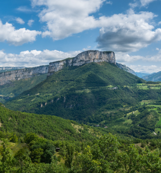 Paysage montagneux de Vercors a lyon sous un ciel bleu et nuageux.
