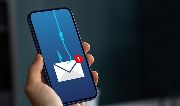 Main tenant un smartphone affichant une icône de message avec un hameçon.