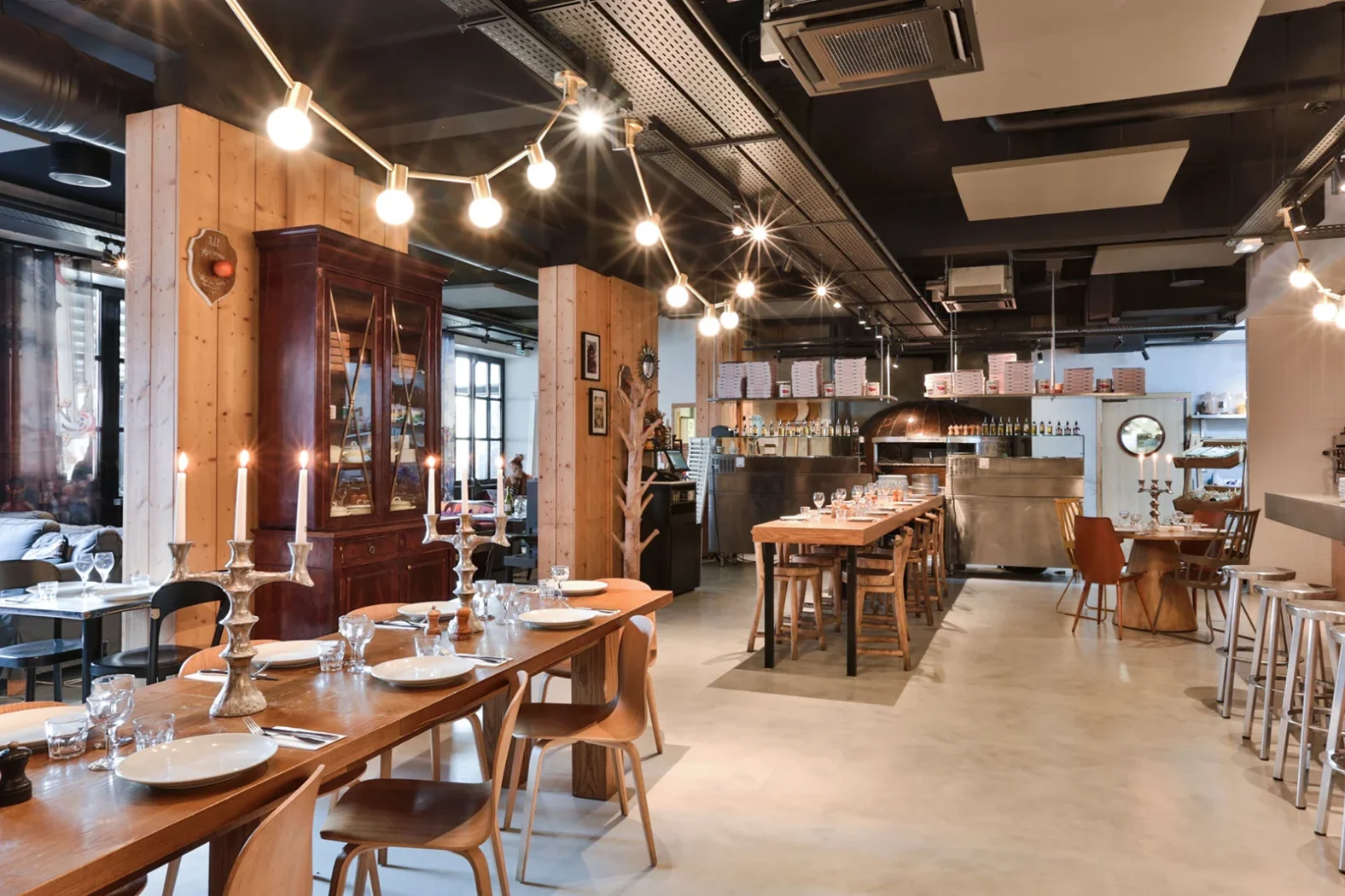 Intérieur chaleureux d’un bouchon lyonnais avec grandes tables en bois et lumière tamisée.