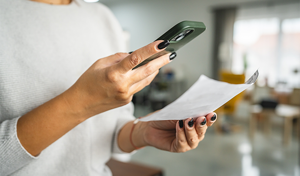 Une personne scanne un billet avec son smartphone pour un contrôle numérique.