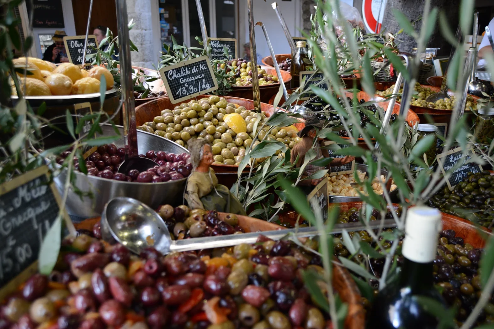 Étals d’olives colorées et de produits locaux sur un marché provençal.