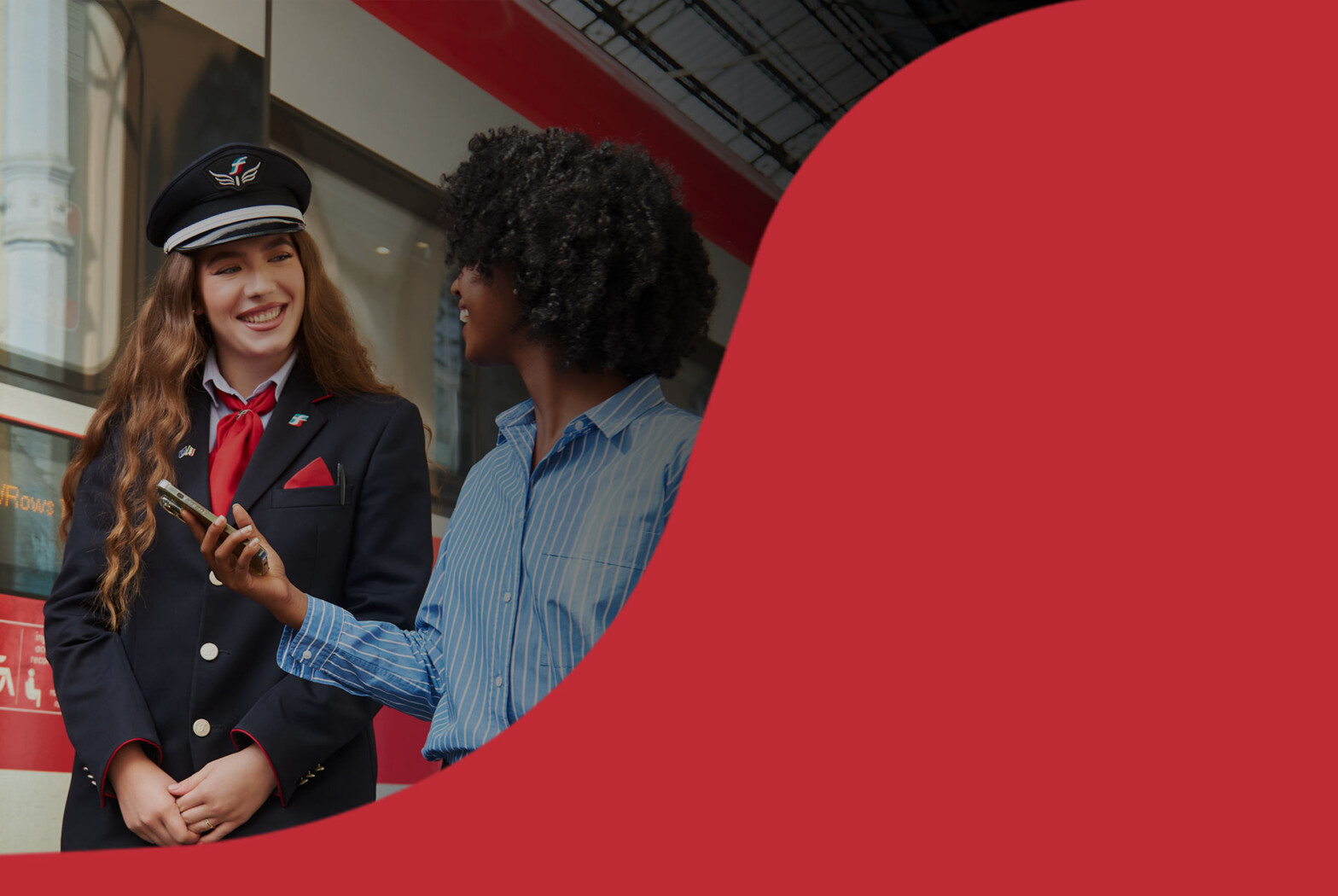 Agent Trenitalia parlant avec une voyageuse sur le quai.