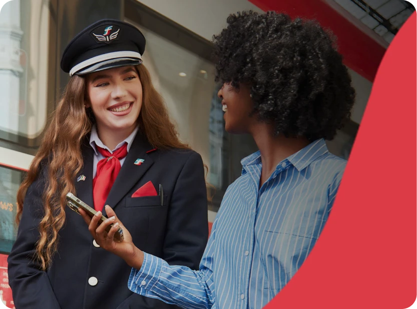 Agent Trenitalia parlant avec une voyageuse sur le quai.