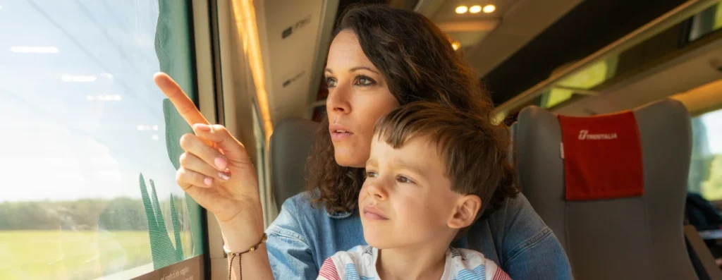 Mère et enfant regardant le paysage depuis un train Trenitalia