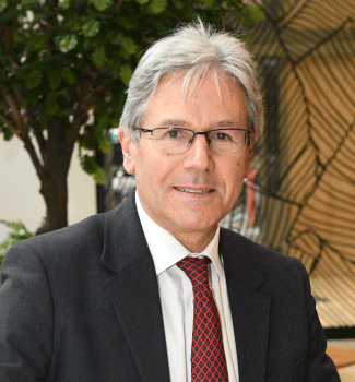 Marco Caposciutti, Président de Trenitalia France, posant en costume sombre et cravate rouge à motifs dans un environnement professionnel avec des plantes en arrière-plan.