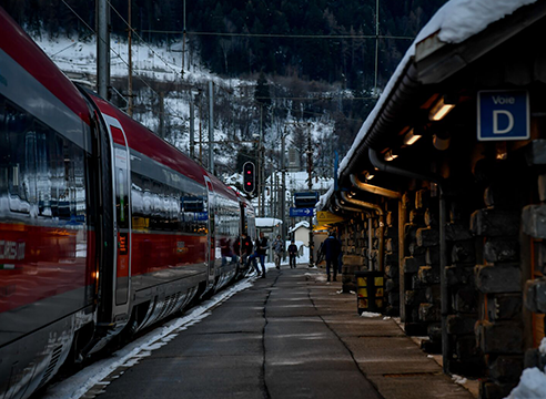 Train Frecciarossa à quai dans une gare enneigée.