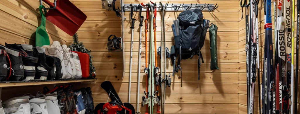 Équipement de ski rangé dans un chalet en bois.