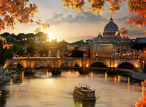 Coucher de soleil sur le Tibre avec la basilique Saint-Pierre et le pont Saint-Ange encadrés par des feuilles d’automne.